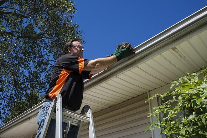 a gutter repair specialist fixing a leaky rain gutter in Acton MA